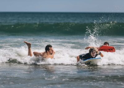 3 people boogy-boarding in the surf and having fun