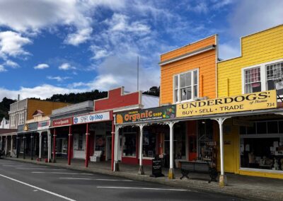 colonial style old fashioned shop fronts in bright colours, blue sky with some cloud tufts