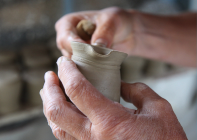 artist hands forming a vessel out of clay