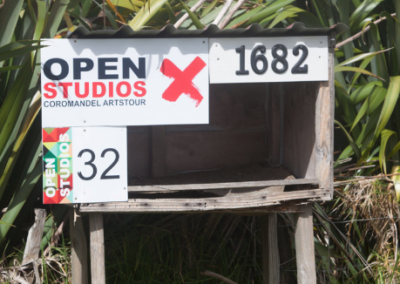 various colourful signs stapled to a roadside vendor box at someone's private driveway